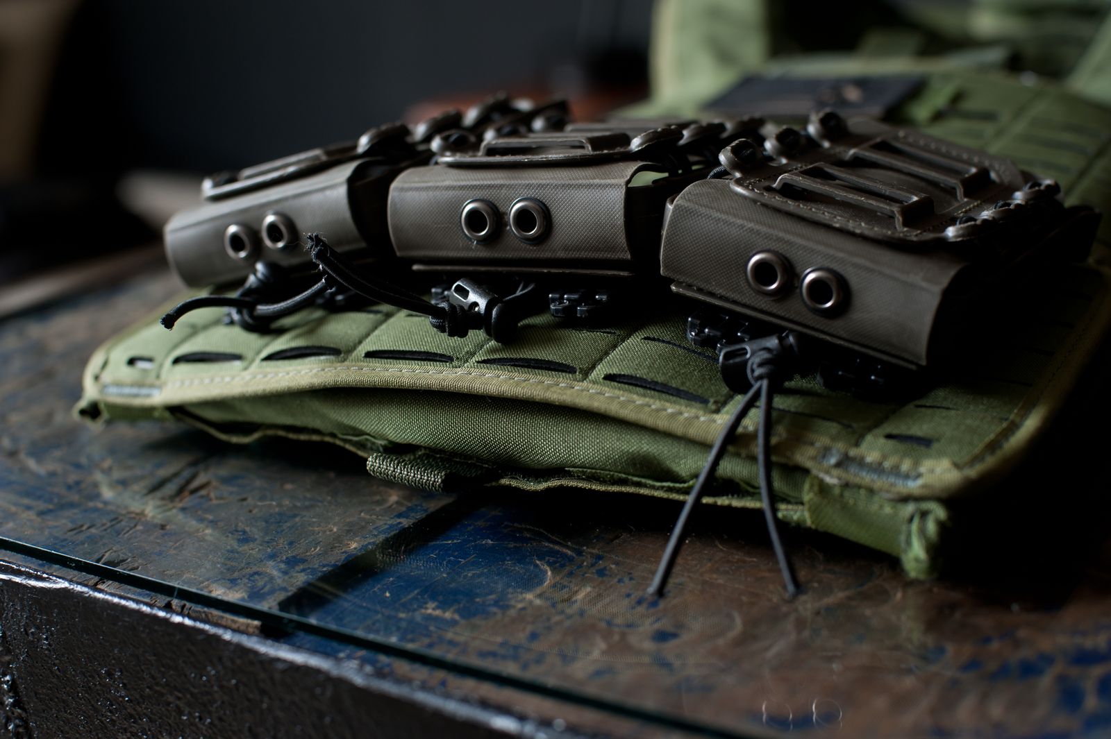 Close-up image of tactical gear and pouches mounted on a green vest.